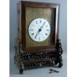 A CHINESE TWIN FUSEE TABLE CLOCK ON STAND, the 17 cms diameter white enamel dial set with Roman