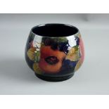 A SMALL MOORCROFT 'POMEGRANATE' SHALLOW FOOTED BOWL decorated on a cobalt ground, impressed '