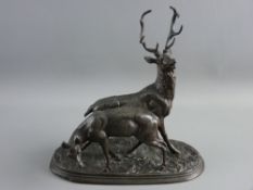 A BRONZED SPELTER STAG & DOE GROUP, modelled in animated pose on a naturalistic oval base,