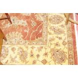 AN INDIAN JAIPUR HAND KNOTTED WOOL PILE CARPET, red ground with a wide cream border having a