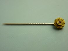 A CASED NINE CARAT GOLD STICK PIN with ruby star cluster, 1.3 grms