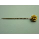 A CASED NINE CARAT GOLD STICK PIN with ruby star cluster, 1.3 grms