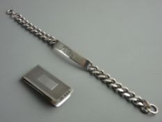 A HALLMARKED SILVER MONEY CLIP and a curb link gent's ID bracelet, Birmingham 1985 and London 1987
