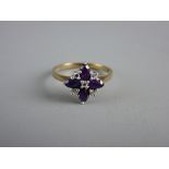 A NINE CARAT GOLD DRESS RING with four floral set oval amethysts and five tiny diamonds, 2.5 grms