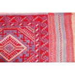 A MESHWANI RUNNER, a deep red ground woven tribal runner with repeated diamond pattern and wide