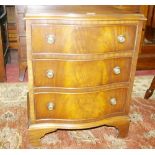 A NEAT REPRODUCTION MAHOGANY SERPENTINE FRONT THREE DRAWER CHEST with brass ring handles and on