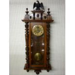 A WALNUT CASED PENDULUM DRIVEN VIENNA STYLE WALL CLOCK, the dial set with Roman numerals and