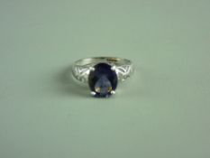 A NINE CARAT WHITE GOLD IOLITE DRESS RING, oblong stone in an attractive pierced set, 3 grms