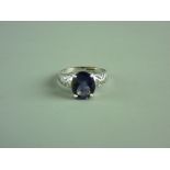 A NINE CARAT WHITE GOLD IOLITE DRESS RING, oblong stone in an attractive pierced set, 3 grms