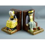 A PAIR OF QUIMPER POTTERY BOOKENDS modelled as a young girl and boy seated on benches, the girl with