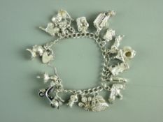 A SILVER CHARM BRACELET with padlock and over fifteen charms, 79 grms