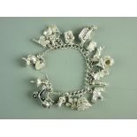 A SILVER CHARM BRACELET with padlock and over fifteen charms, 79 grms