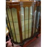 A vintage serpentine front two-door china display cabinet