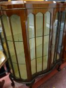 A vintage serpentine front two-door china display cabinet