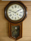 An oak encased circular dial pendulum wall clock