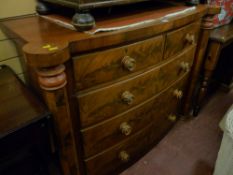 A Victorian bow fronted chest of two short over three long drawers with turned wooden knobs inset
