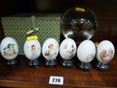 A collection of Oriental porcelain eggs on stands, a crystal ball etc