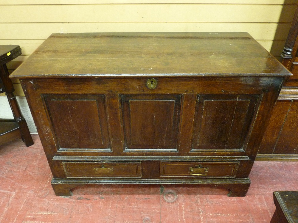 A LATE 18th/EARLY 19th CENTURY OAK DOWER CHEST having a triple fielded panel front with two base
