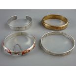 FOUR SILVER BANGLE BRACELETS including a gilt half chased decorated example, stamped Birmingham