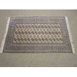 AN EARLY 20th CENTURY GREY GROUND TURKOMAN RUG having a wide nine row border and the centre having a
