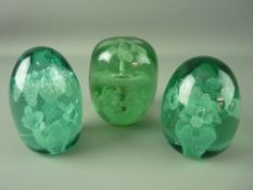 THREE VICTORIAN GREEN GLASS DUMP PAPERWEIGHTS, all having multiple floral inclusions, 10 cms high