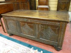 AN 18th CENTURY OAK DOWER CHEST having three inset carved panels and on four corner bun supports,