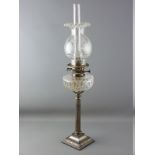 A VICTORIAN OIL LAMP with metal Corinthian column having a clear glass reservoir and clear etched