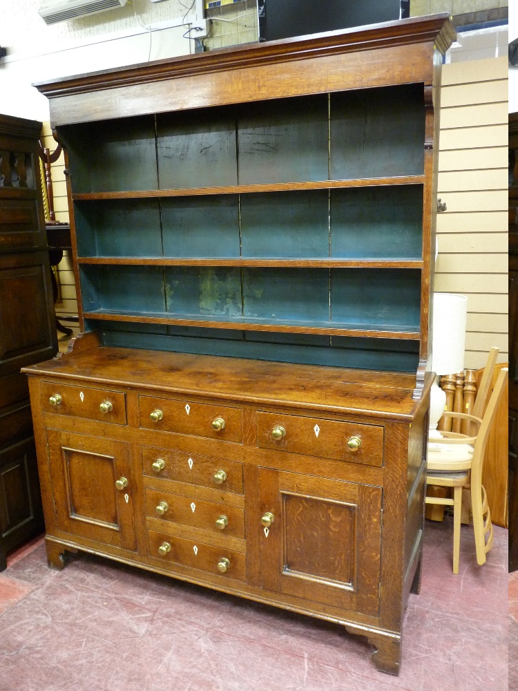 AN EARLY TO MID 19th CENTURY OAK NORTH WALES DRESSER having a three shelf rack over a base having
