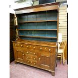 AN EARLY TO MID 19th CENTURY OAK NORTH WALES DRESSER having a three shelf rack over a base having