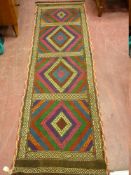 A SUZNI KILIM RUNNER, colourful diamond chevron panels with a narrow banded stitched edge border,