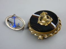 A CIRCULAR YELLOW METAL ROPE TWIST FRAMED AGATE BROOCH with dolphin to the centre and a silver and