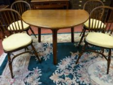 A QUALITY REPRODUCTION OAK CRICKET TYPE DINING TABLE and four hoop spindlebacked dining chairs