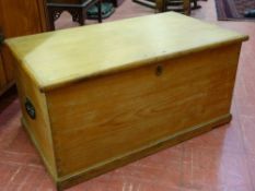 AN ANTIQUE STRIPPED PINE BOX with iron carry handles and strap hinges, the interior with two