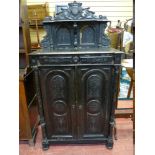 A 19th CENTURY EUROPEAN EBONIZED SIDE CABINET, the top shelf sectioned with carved detail repeated