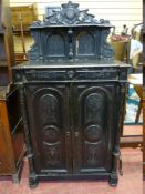 A 19th CENTURY EUROPEAN EBONIZED SIDE CABINET, the top shelf sectioned with carved detail repeated