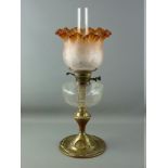 A VICTORIAN OIL LAMP with brass column, clear glass reservoir and amber coloured etched glass shade