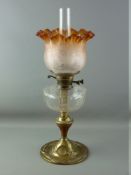 A VICTORIAN OIL LAMP with brass column, clear glass reservoir and amber coloured etched glass shade