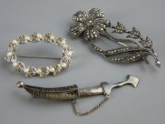 A MARCASITE FLORAL BROOCH, a marcasite and pearl oval brooch and a small white metal dagger brooch