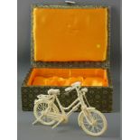 A CHINESE MINIATURE CARVED IVORY BICYCLE, fully reticulated and detailed with folding support stand,