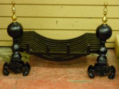 A CAST IRON FIRE BASKET on a pair of brass top dog irons, 61 cms wide