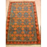 A BALOCHI RUG, crimson red and blue ground with central repeating tree and floral pattern with zig