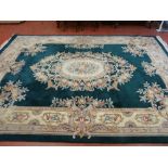 LARGE CHINESE WASHED CARPET, primarily green in colour with unusual floral decoration, 3.7 x 2.7