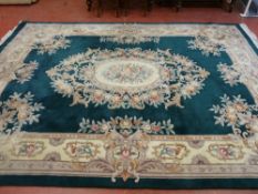 LARGE CHINESE WASHED CARPET, primarily green in colour with unusual floral decoration, 3.7 x 2.7
