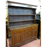 A 19th CENTURY WELSH OAK DRESSER, the shaped sided two shelf rack with wide backboards over a