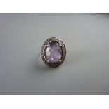 A SILVER DRESS RING with a large oval purple quartz with surrounding tiny marcasites, 6 grms total