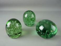 THREE VICTORIAN GREEN GLASS DUMP PAPERWEIGHTS all having bubble interior inclusions, 12 cms diameter