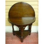 A POLISHED CIRCULAR TOPPED FOLDOVER GATE LEG SIDE TABLE with a triangular base shelf having turned