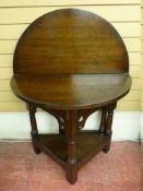 A POLISHED CIRCULAR TOPPED FOLDOVER GATE LEG SIDE TABLE with a triangular base shelf having turned