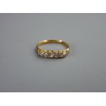 AN EIGHTEEN CARAT GOLD DRESS RING with five tiny diamonds, 2.5 grms, size 'Q'