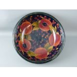 A MOORCROFT 'POMEGRANATE' IMPRESSIVE 33 cms DIAMETER FRUIT BOWL, decorated inside and out, on a